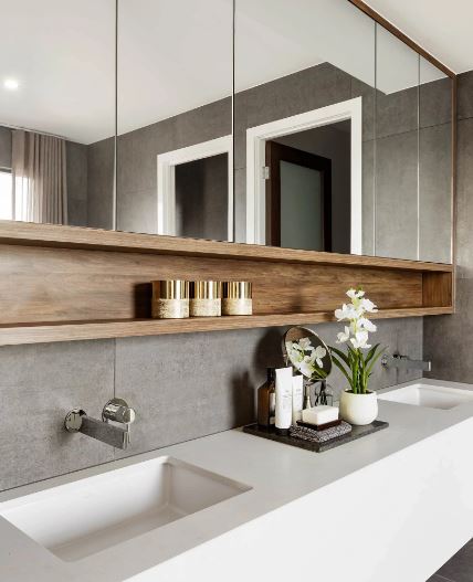 Double vanity with gray stone tile, a walnut shelf and a white orchid