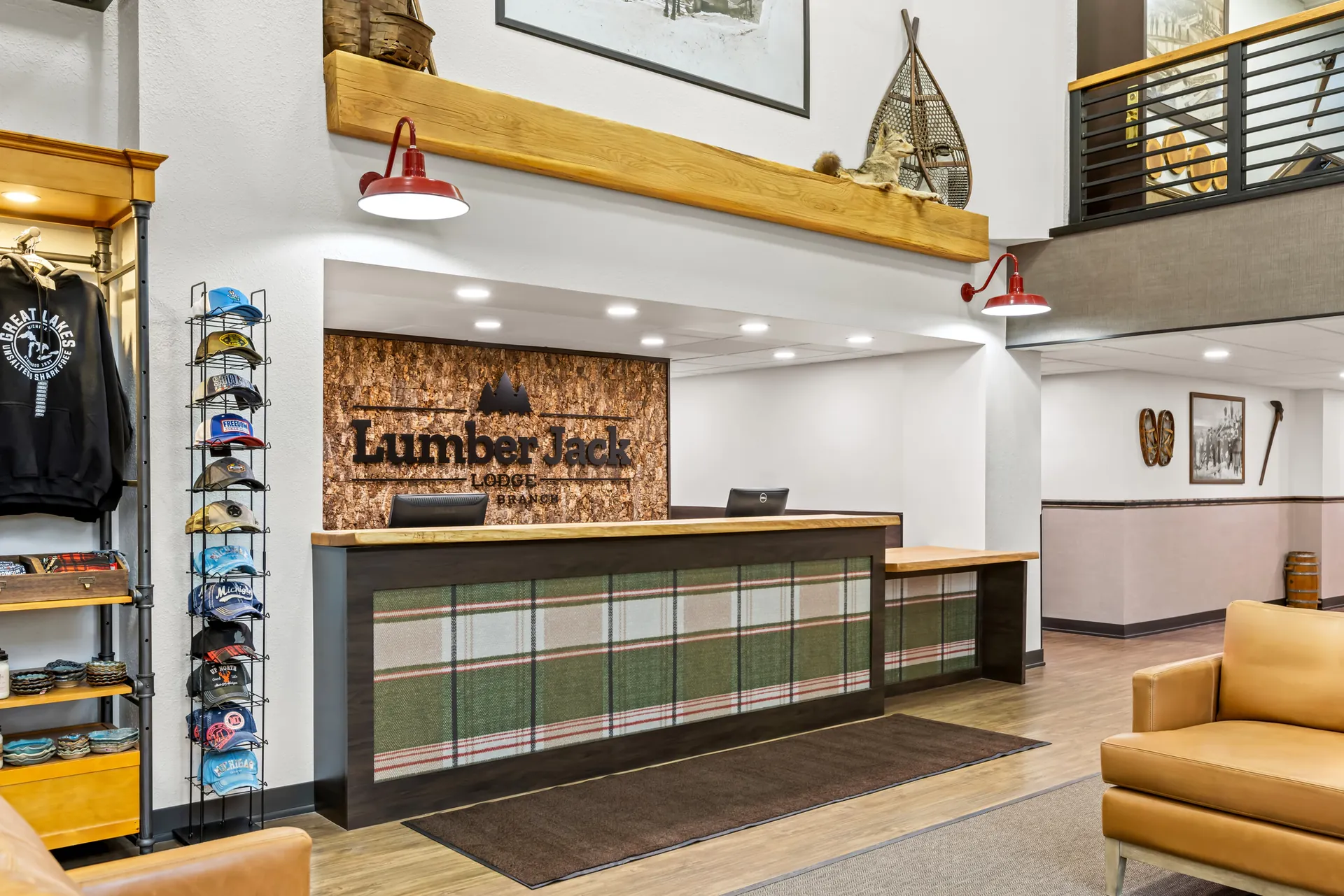 Lumber Jack Lodge front desk with a plaid-paneled counter, bark logo wall and red barn lights